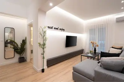 a living room with a couch and a tv at Exclusive and Deluxe Apartment in Athens City in Athens