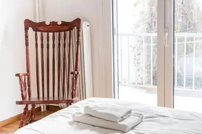 a room with a chair and a bed with towels at Sunny n Luxury apt in Glyfadas center in Athens