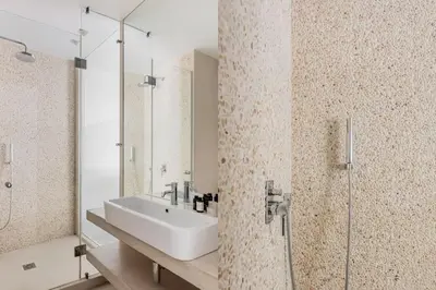a bathroom with a sink and a glass shower at Contemporary Bliss 2BR Apartment in Athens by UPSTREET in Athens