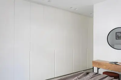a bedroom with white walls and a table and a mirror at Contemporary Bliss 2BR Apartment in Athens by UPSTREET in Athens