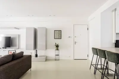a white living room with a couch and a table at Contemporary Bliss 2BR Apartment in Athens by UPSTREET in Athens