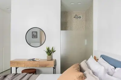 a bedroom with a bed and a table with a mirror at Contemporary Bliss 2BR Apartment in Athens by UPSTREET in Athens