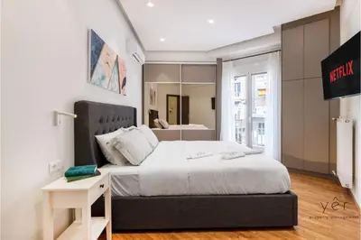 a bedroom with a large bed and a mirror at Nature-Infused Vibes & Nightlife in Athens