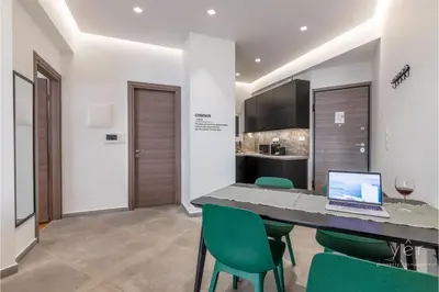 a dining room with a table with a laptop on it at Nature-Infused Vibes & Nightlife in Athens