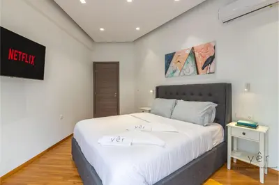 a bedroom with a large bed with white sheets at Nature-Infused Vibes & Nightlife in Athens