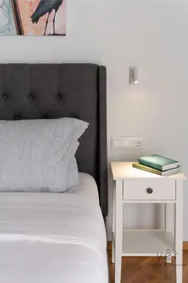 a bed with a white nightstand next to a white table with a nightstand at Nature-Infused Vibes & Nightlife in Athens