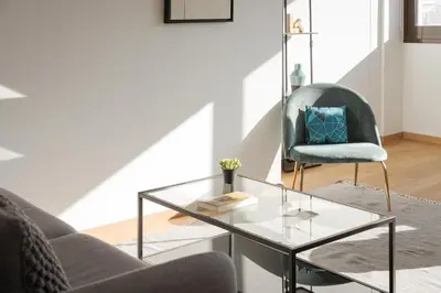 a living room with a glass table and a chair at Syntagma Unique Penthouse in Athens