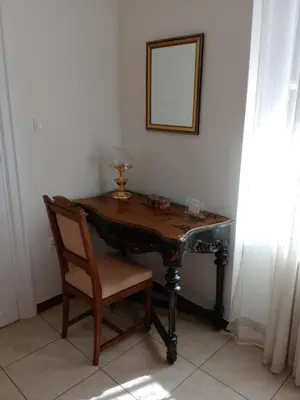 a wooden table with a chair and a mirror at Calliope's Neoclassical Home in the heart of Plaka in Athens