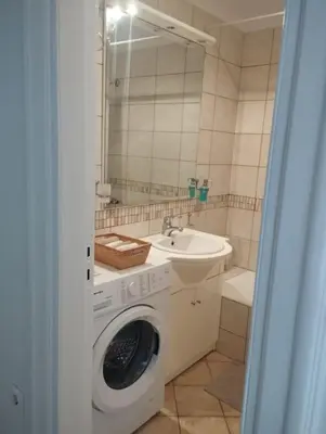 a bathroom with a washing machine and a sink at Calliope's Neoclassical Home in the heart of Plaka in Athens