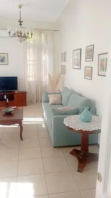 a living room with a blue couch and a table at Calliope's Neoclassical Home in the heart of Plaka in Athens