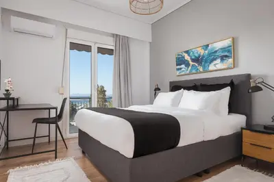 a bedroom with a bed and a desk and a window at Glyfada Cozy Living in Athens