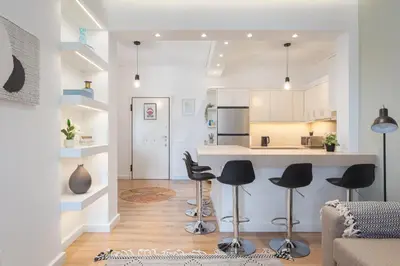 a kitchen with black stools in a living room at Glyfada Cozy Living in Athens