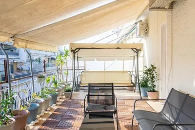 a balcony with a table and chairs and potted plants at Urban Oasis Terrace 2Bebroom apartment in Athens