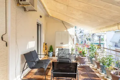 a patio with chairs and potted plants on a balcony at Urban Oasis Terrace 2Bebroom apartment in Athens