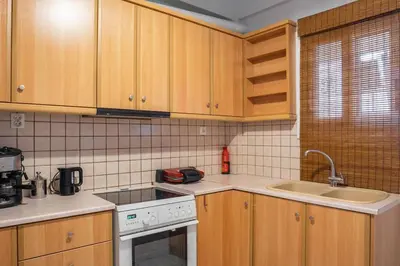 a kitchen with wooden cabinets and a stove and sink at Urban Oasis Terrace 2Bebroom apartment in Athens