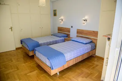 two beds in a room with wood floors at Batis Sea View in Athens
