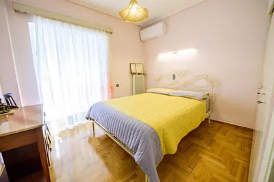 a bedroom with a bed with a yellow blanket at Batis Sea View in Athens