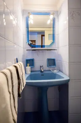 a bathroom with a blue sink and a mirror at Batis Sea View in Athens
