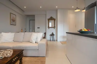 a living room with a white couch and a table at Pagkrati Urban Living in Athens