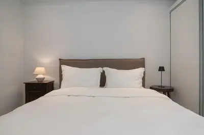 a bedroom with a large bed with white sheets and pillows at Pagkrati Urban Living in Athens