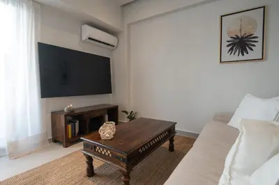 a living room with a couch and a tv at Pagkrati Urban Living in Athens