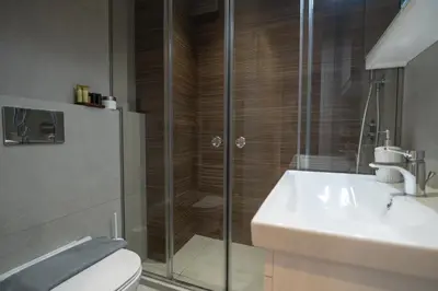a bathroom with a shower and a toilet and a sink at Pagkrati Urban Living in Athens