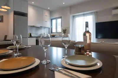 a table with two glasses and a bottle of wine at Pagkrati Urban Living in Athens