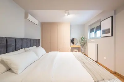 a bedroom with a large white bed with white pillows at Artistic 2BR Maisonette: An Architectural Delight in Athens