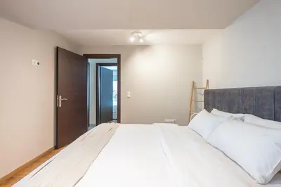 a bedroom with a large bed with white sheets at Artistic 2BR Maisonette: An Architectural Delight in Athens