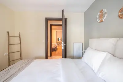 a bedroom with a white bed and a doorway at Artistic 2BR Maisonette: An Architectural Delight in Athens