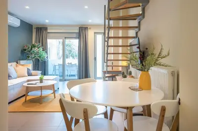 a living room with a white table and chairs at Artistic 2BR Maisonette: An Architectural Delight in Athens
