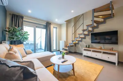 a living room with a couch and a tv at Artistic 2BR Maisonette: An Architectural Delight in Athens