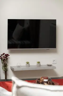 a living room with a television on a wall at Starfish Complex in Porto Rafti