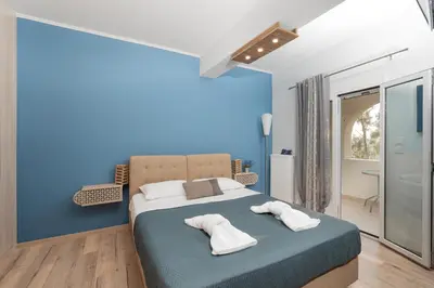 a blue bedroom with a bed with two pillows at Starfish Complex in Porto Rafti