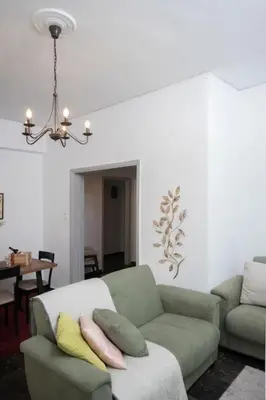 a living room with a couch and a chandelier at Lovely,central, spacious 2-bedrooms apartment in Piraeus