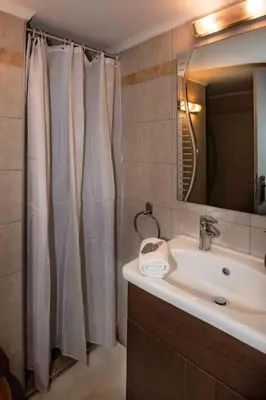 a bathroom with a sink and a shower curtain at Lovely,central, spacious 2-bedrooms apartment in Piraeus
