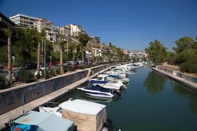 a row of boats docked in a river with buildings at Lovely,central, spacious 2-bedrooms apartment in Piraeus