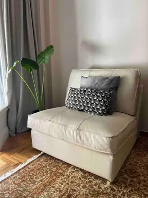 a couch with two pillows on it in a living room at 4th floor cosy apartment in Metaxourgeio in Athens