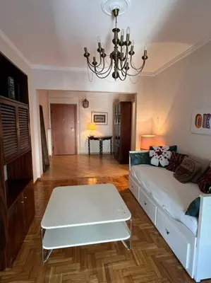 a living room with a white couch and a chandelier at 4th floor cosy apartment in Metaxourgeio in Athens