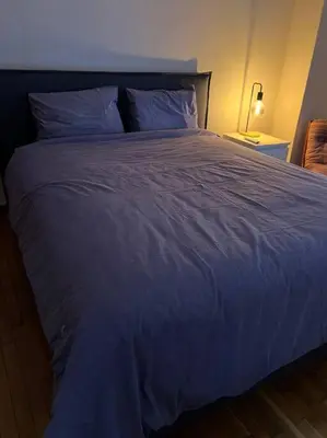 a large bed with a blue comforter in a bedroom at 4th floor cosy apartment in Metaxourgeio in Athens