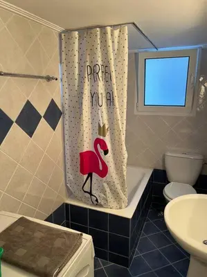 a bathroom with a shower curtain with a flamingo on it at 4th floor cosy apartment in Metaxourgeio in Athens