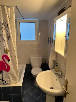 a bathroom with a sink and a toilet and a window at 4th floor cosy apartment in Metaxourgeio in Athens