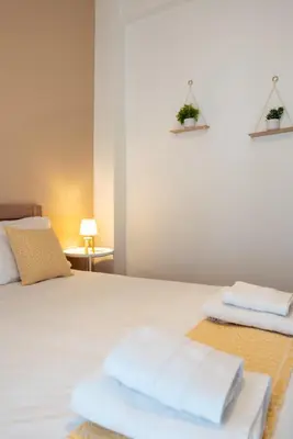a bedroom with a white bed with towels on it at City Break Apartment 4' to Metro in Athens