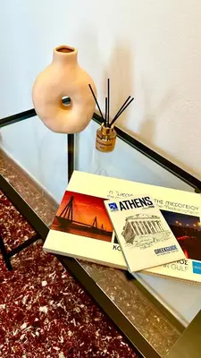 a stack of books on a glass table with a lamp at City Break Apartment 4' to Metro in Athens