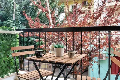 a wooden table on a balcony with two plants at City Break Apartment 4' to Metro in Athens