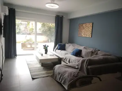 a living room with a couch and a table at Ground floor apt. with garden, Timfristou 86 Chalandri in Athens