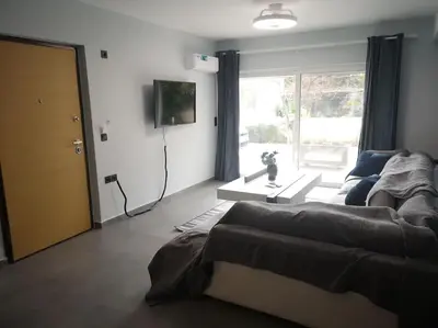 a living room with a couch and a tv at Ground floor apt. with garden, Timfristou 86 Chalandri in Athens