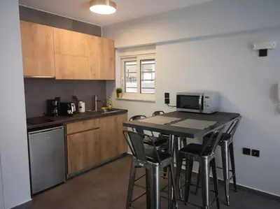 a kitchen with a table with chairs and a microwave at Ground floor apt. with garden, Timfristou 86 Chalandri in Athens