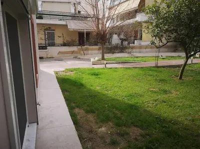 a view of a yard of a building with a sidewalk at Ground floor apt. with garden, Timfristou 86 Chalandri in Athens