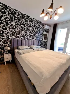 a bedroom with a large bed with a black and white wall at Luxurious studio apartment close to the beach and airport in Porto Rafti